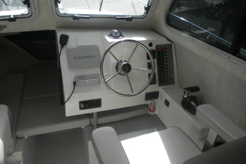 Slide: The Image of 2024 Parker 2320 SL Sport Cabin interior with Garmin navigation system and steering wheel. - 11