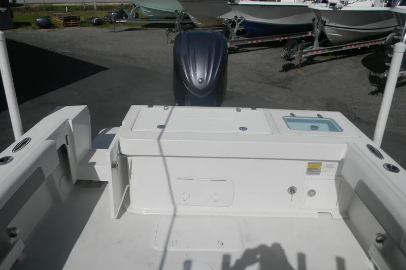 Slide: The Image of 2024 Parker 2320 SL Sport Cabin boat deck with engine and storage compartments. - 6