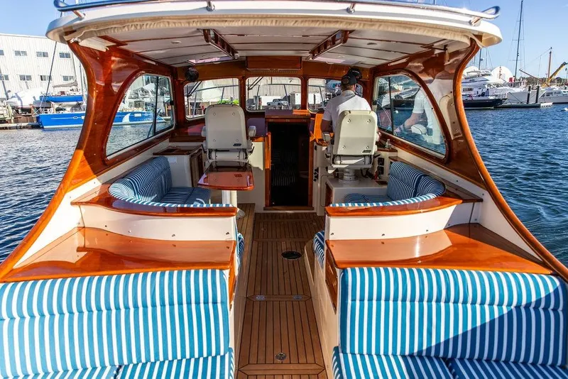 Slide: The Image of Interior view of 2007 Hinckley Talaria 40 yacht with striped seating and wooden finishes. - 11