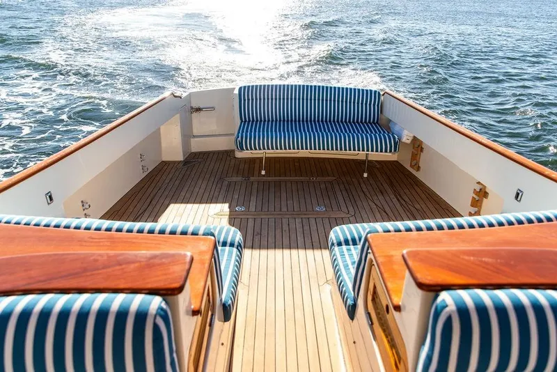 Slide: The Image of Hinckley Talaria 40, 2007 model, featuring striped seating and wooden deck on open water. - 12