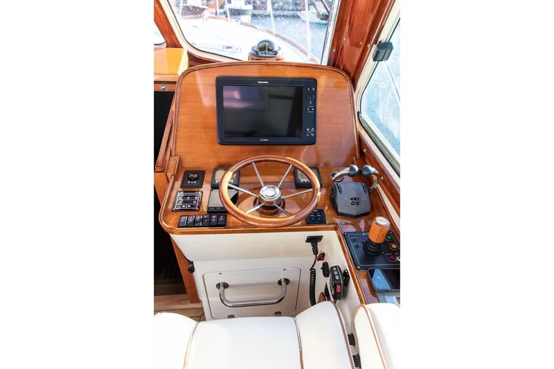 Slide: The Image of Helm station of 2007 Hinckley Talaria 40 with wooden steering wheel and navigation controls. - 17