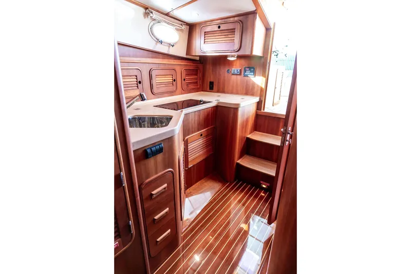 Slide: The Image of Luxurious wooden interior of 2007 Hinckley Talaria 40 yacht, featuring a compact kitchen area. - 23