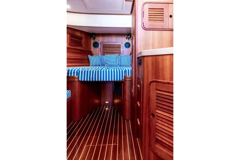 Slide: The Image of Interior of 2007 Hinckley Talaria 40 yacht with striped bedding and wooden finishes. - 25