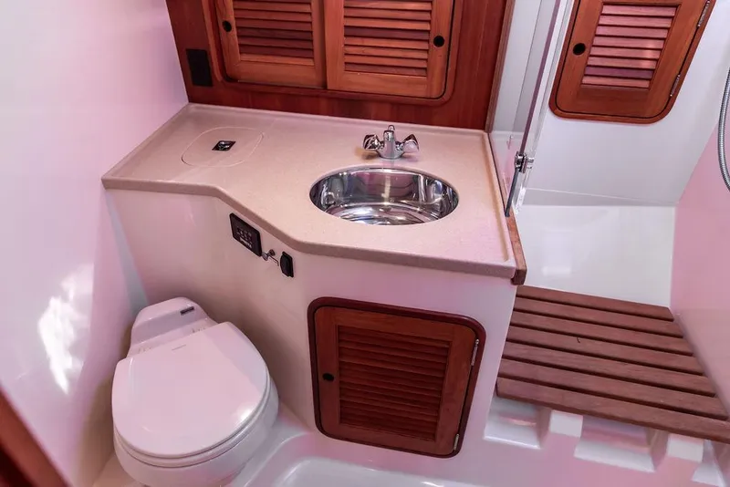Slide: The Image of 2007 Hinckley Talaria 40 yacht bathroom with sink, toilet, and wooden cabinetry. - 27