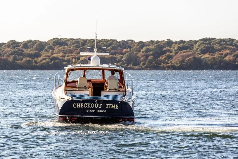 Slide: The Image of 2007 Hinckley Talaria 40 boat named "Checkout Time" cruising on scenic waterway. - 6