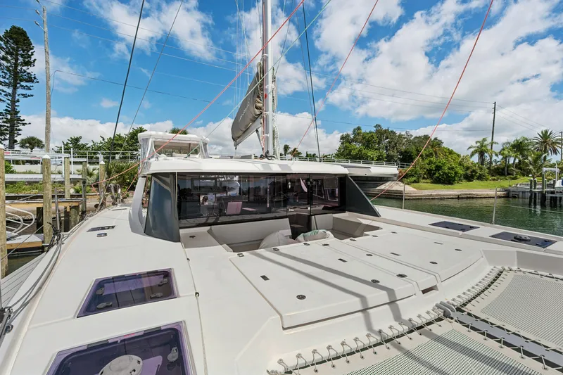 Slide: The Image of 2021 Leopard 45 catamaran docked, showcasing sleek design and spacious deck under a clear sky. - 10