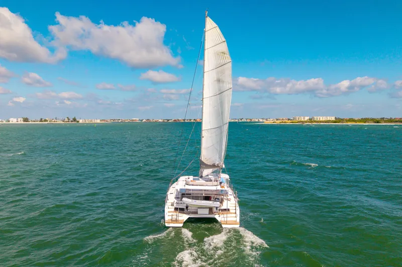 Slide: The Image of 2021 Leopard 45 catamaran sailing on open sea under clear blue sky. - 111