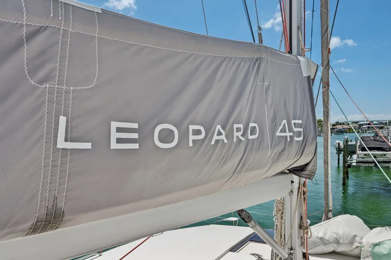 Slide: The Image of 2021 Leopard 45 sailboat with branded cover docked at marina. - 12