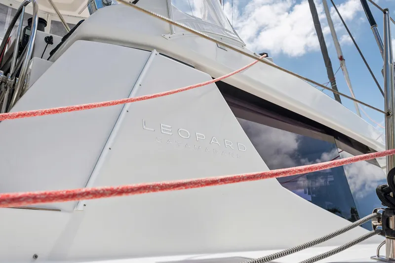 Slide: The Image of 2021 Leopard 45 catamaran with sleek design and red ropes against a blue sky. - 13
