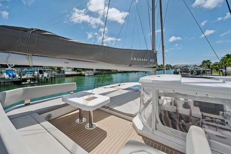 Slide: The Image of 2021 Leopard 45 catamaran with spacious deck, docked in a sunny marina. - 18