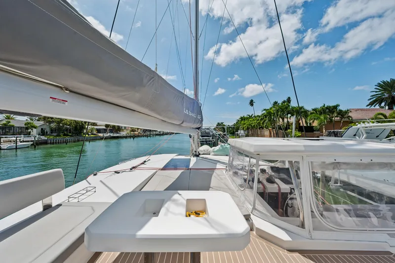 Slide: The Image of 2021 Leopard 45 catamaran deck with seating, docked in a sunny marina. - 19
