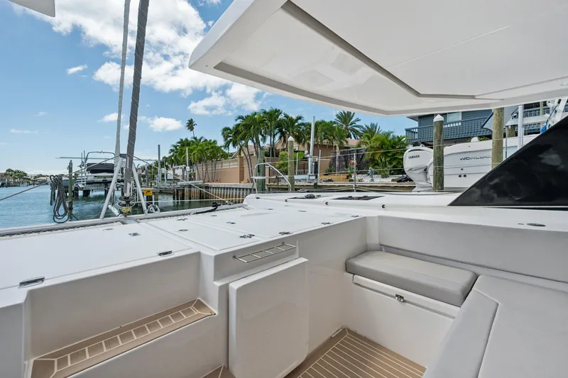 Slide: The Image of 2021 Leopard 45 yacht deck with seating, docked near palm trees and water. - 23