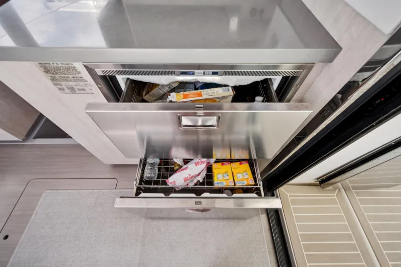 Slide: The Image of Stainless steel drawers in a 2021 Leopard 45 yacht kitchen, storing various food items. - 30