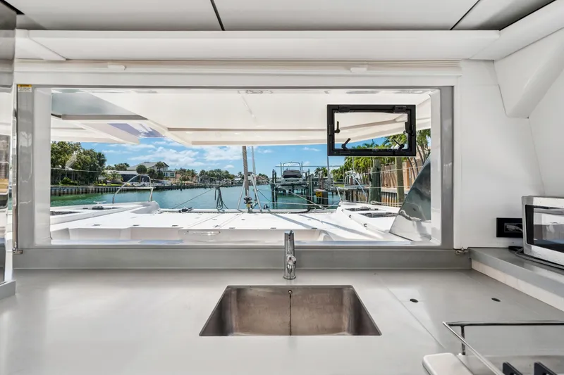 Slide: The Image of Interior view from a 2021 Leopard 45 yacht, showcasing a sleek kitchen and scenic marina. - 37