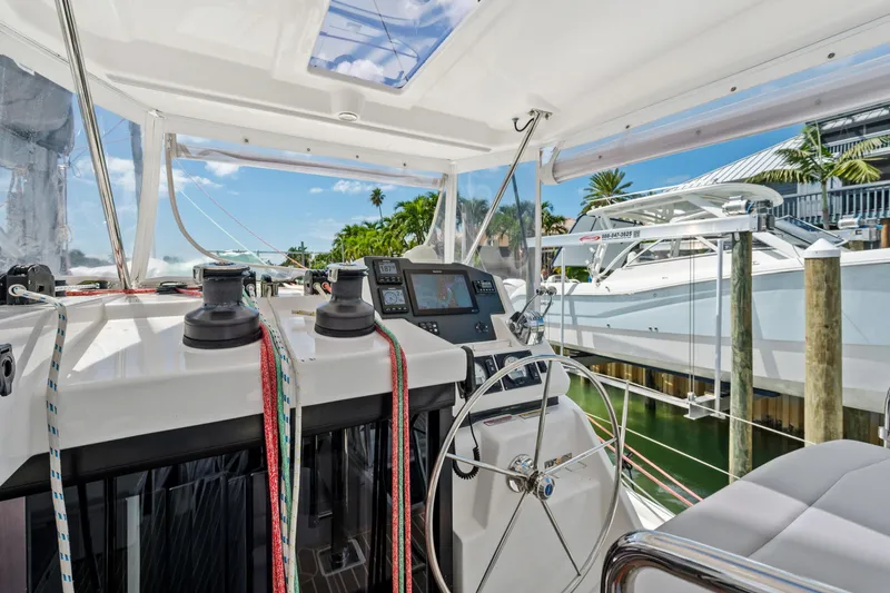 Slide: The Image of Leopard 45 catamaran helm with navigation equipment, ropes, and steering wheel, docked in marina. - 53