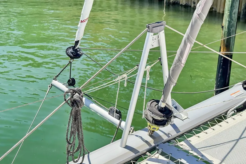 Slide: The Image of Rope rigging on a 2021 Leopard 45 catamaran, docked in calm green water. - 7