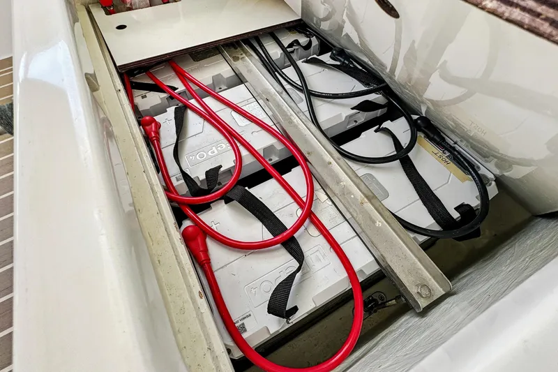 Slide: The Image of Battery compartment of a 2021 Leopard 45 yacht with red cables and secured batteries. - 99