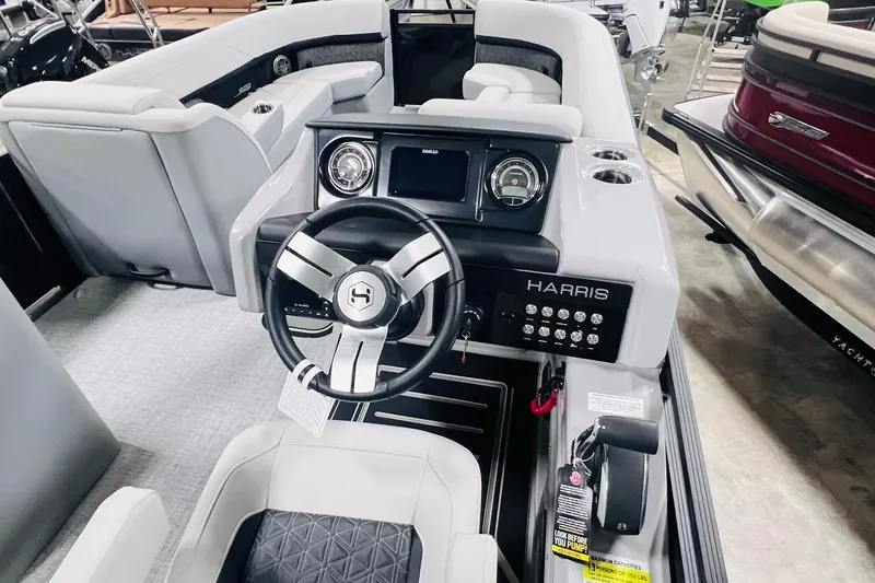 Slide: The Image of Interior view of 2025 Harris Solstice 250 boat, featuring modern steering and dashboard controls. - 19