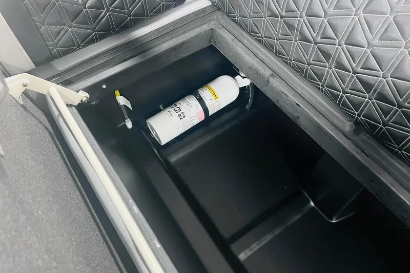 Slide: The Image of Storage compartment in 2025 Harris Solstice 250 with fire extinguisher and quilted interior. - 48