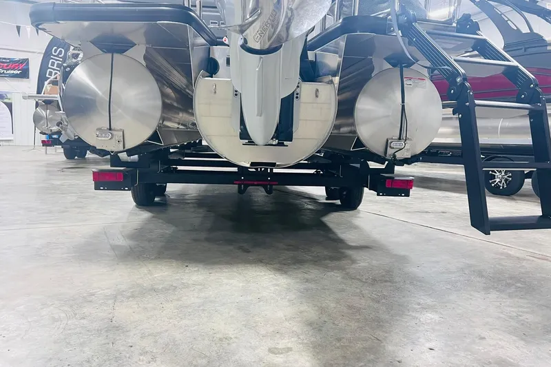 Slide: The Image of 2025 Harris Solstice 250 pontoon boat rear view in showroom setting. - 53