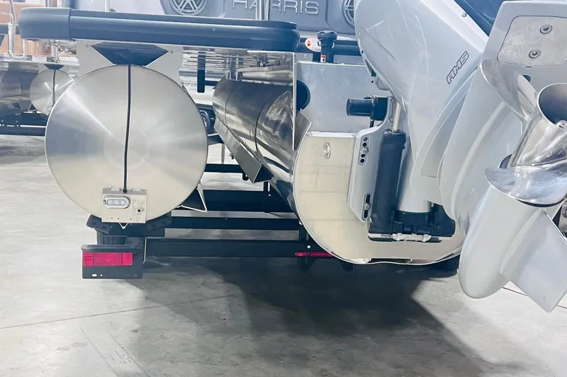 Slide: The Image of Rear view of 2025 Harris Solstice 250 pontoon boat in a showroom. - 54