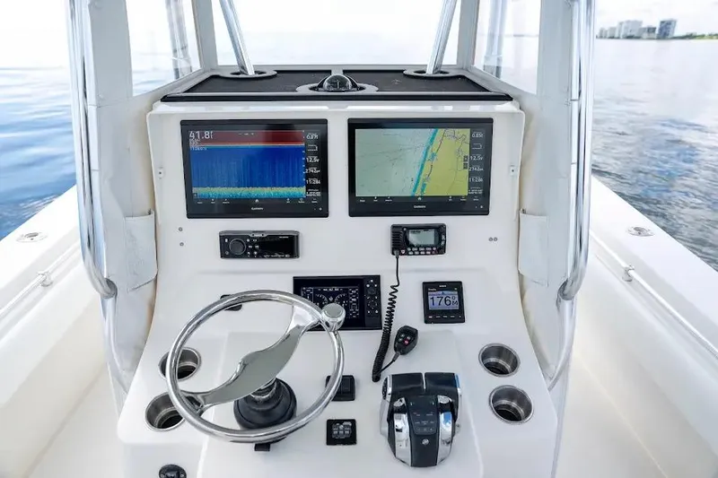 Slide: The Image of 2013 Contender 35 ST boat dashboard with navigation screens and controls on calm water. - 11