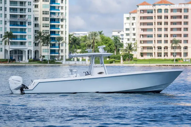 Slide: The Image of 2013 Contender 35 ST boat on water, with modern buildings in the background. - 2