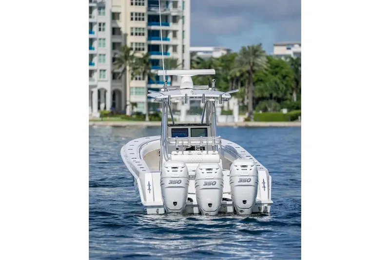 Slide: The Image of 2013 Contender 35 ST boat with triple 350 engines on water, near luxury buildings. - 6