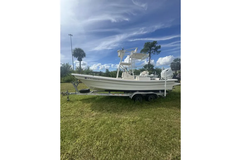 The Image of 2021 Panga Captiva boat on trailer, parked on grassy area under blue sky. - 1