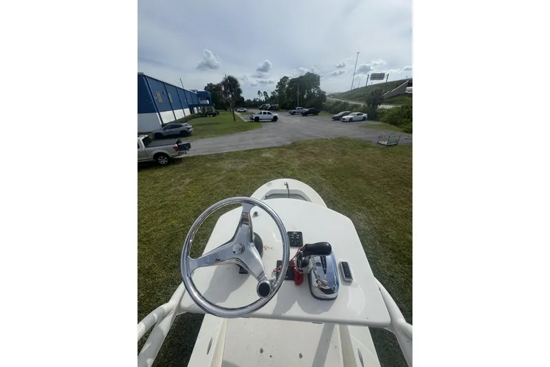 Slide: The Image of 2021 Panga Captiva boat steering wheel and controls, parked outdoors near a building. - 12