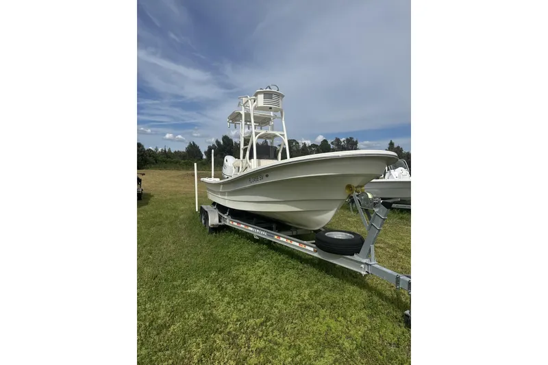 Slide: The Image of 2021 Panga Captiva boat on trailer, parked on grassy field under blue sky. - 3