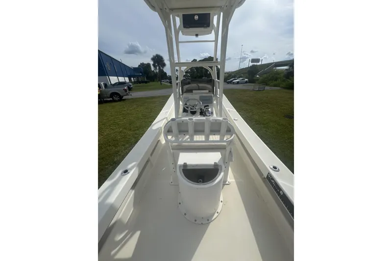 Slide: The Image of 2021 Panga Captiva boat interior with steering console and seating, parked outdoors. - 7
