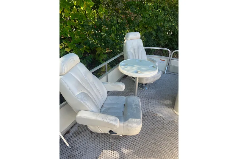 Slide: The Image of 2026 Bennington 2575 RLX boat interior with two white seats and a round table. - 11