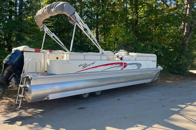 Slide: The Image of 2026 Bennington 2575 RLX pontoon boat parked on a shaded road. - 4