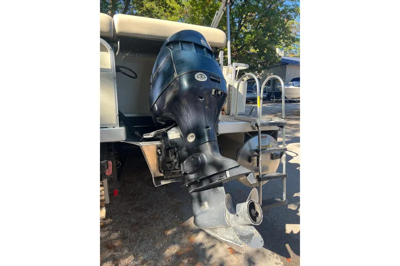 Slide: The Image of 2026 Bennington 2575 RLX boat with powerful outboard motor in a sunny outdoor setting. - 6
