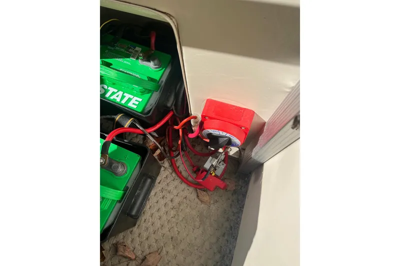 Slide: The Image of Battery compartment of 2026 Bennington 2575 RLX with wiring and switch. - 7