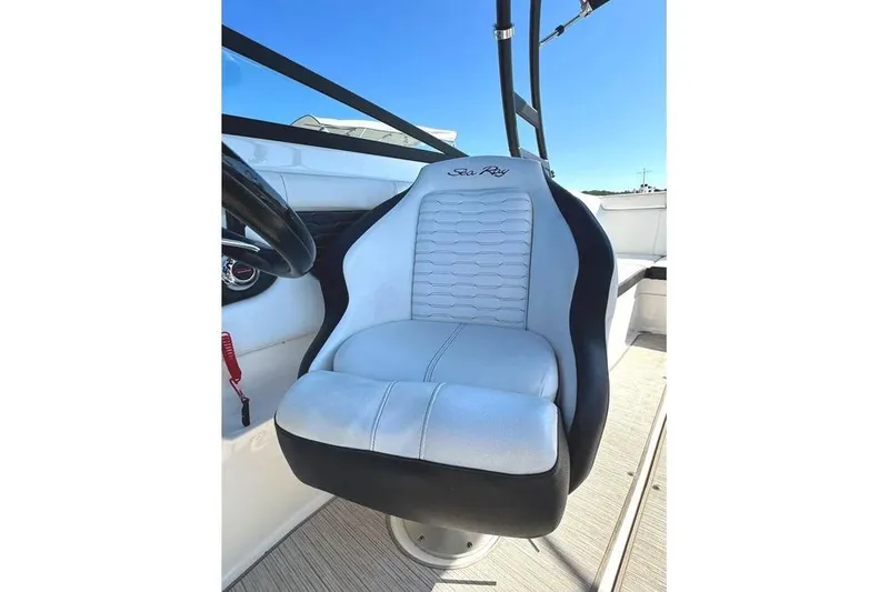 Slide: The Image of 2022 Sea Ray SPX 230 Outboard boat seat, white and black design, sunny day. - 19