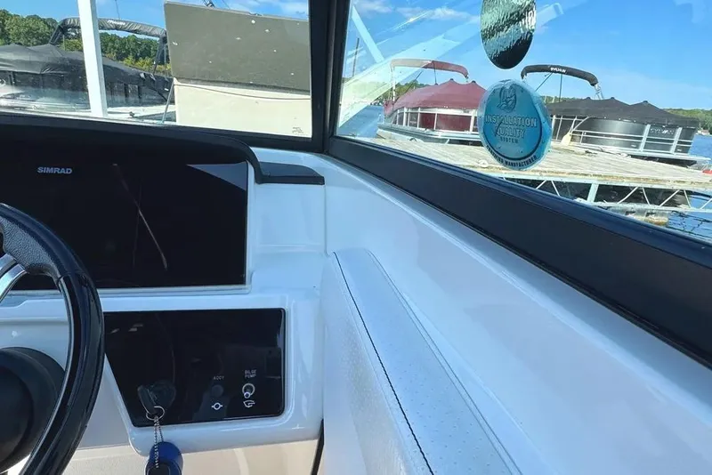 Slide: The Image of 2022 Sea Ray SPX 230 Outboard dashboard with Simrad display and marina view. - 21