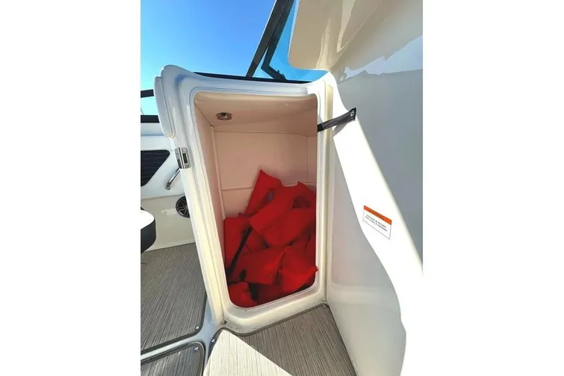 Slide: The Image of Storage compartment with life jackets on a 2022 Sea Ray SPX 230 Outboard boat. - 26