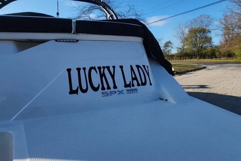 Slide: The Image of 2022 Sea Ray SPX 230 Outboard boat named "Lucky Lady" docked outdoors. - 5