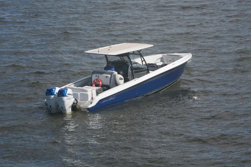 Slide: The Image of 2018 Nor-Tech 340 Sport Center Console boat on water, featuring dual Mercury engines. - 2