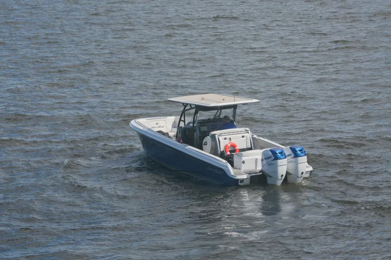 Slide: The Image of 2018 Nor-Tech 340 Sport Center Console boat on open water with dual engines. - 5