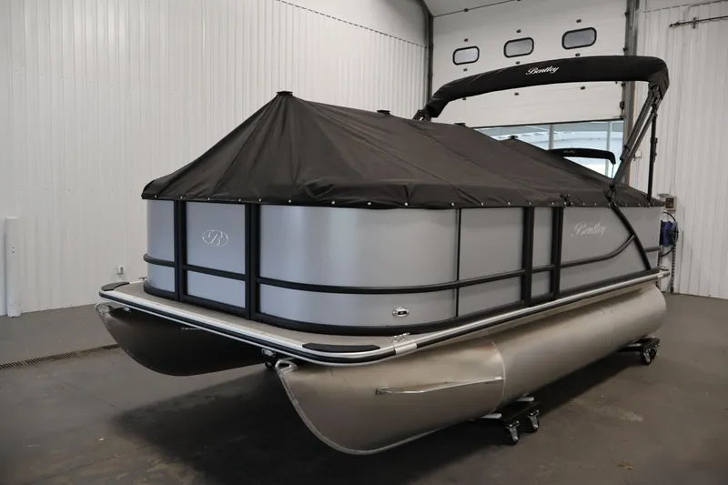 Slide: The Image of 2026 Bentley Pontoons 160 Cruise LE with cover in a showroom setting. - 31