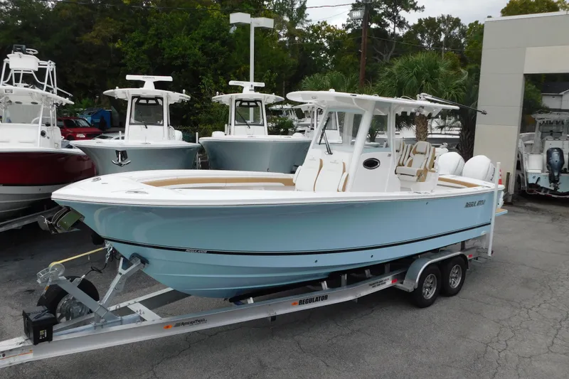 The Image of 2026 Regulator 28 boat on trailer, light blue hull, parked outdoors. - 0