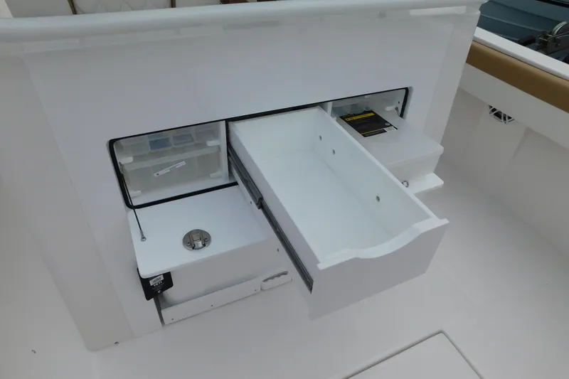 Slide: The Image of 2026 Regulator 28 boat storage compartment with open drawers and tackle box. - 19