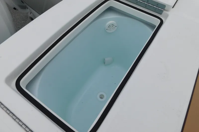 Slide: The Image of Livewell compartment on a 2026 Regulator 28 boat, featuring a clean, white interior. - 22
