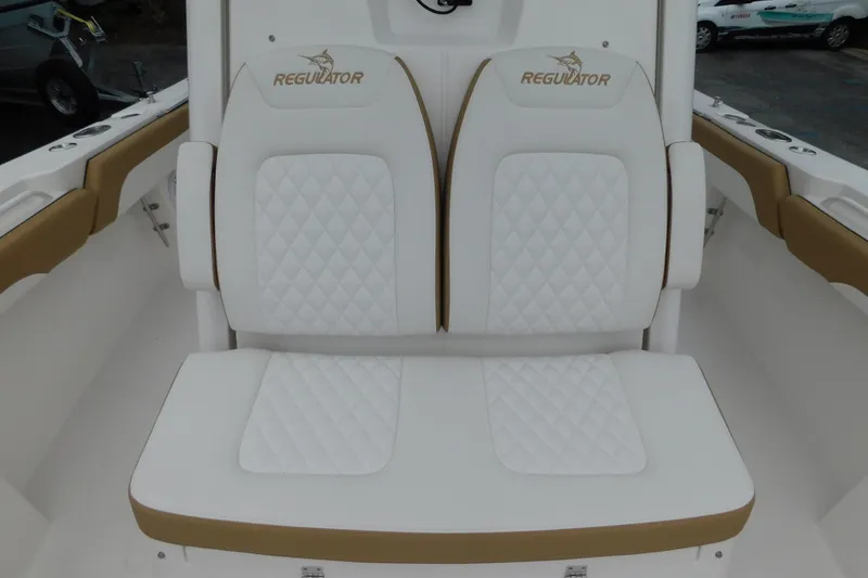 Slide: The Image of 2026 Regulator 28 boat seating with white quilted upholstery and Regulator logo. - 29