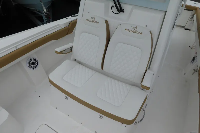 Slide: The Image of 2026 Regulator 28 boat with white and tan cushioned seating, featuring diamond stitching. - 31