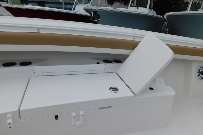 Slide: The Image of 2026 Regulator 28 boat interior with open storage compartment and cup holders. - 32