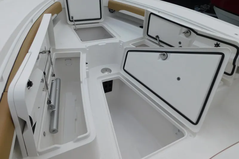 Slide: The Image of 2026 Regulator 28 boat with open storage compartments and tan seating. - 34